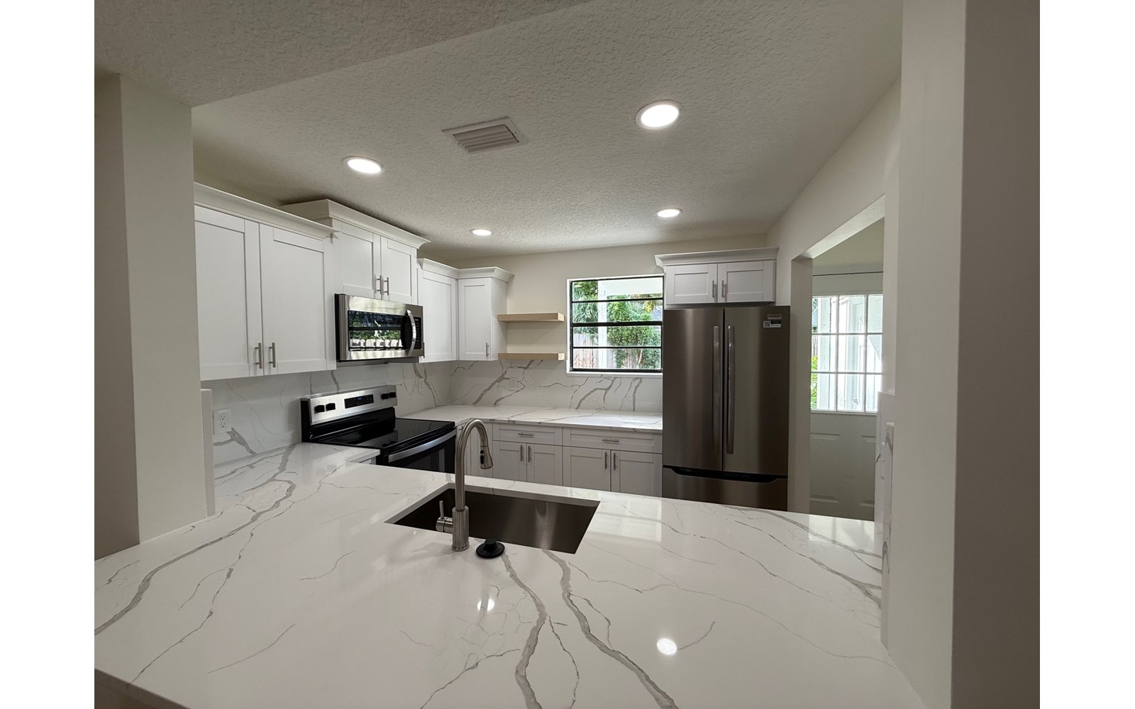 Bright white shaker kitchen remodel with marble-look countertops